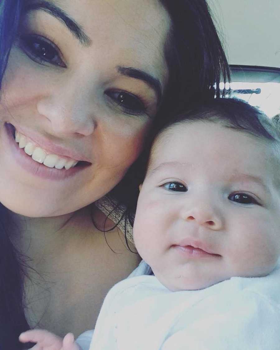Mom takes a selfie with her newborn child during a car ride