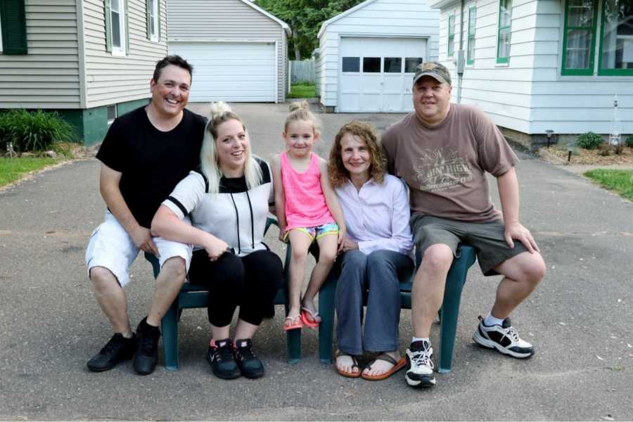 Two sisters take a family photo with their husbands and children