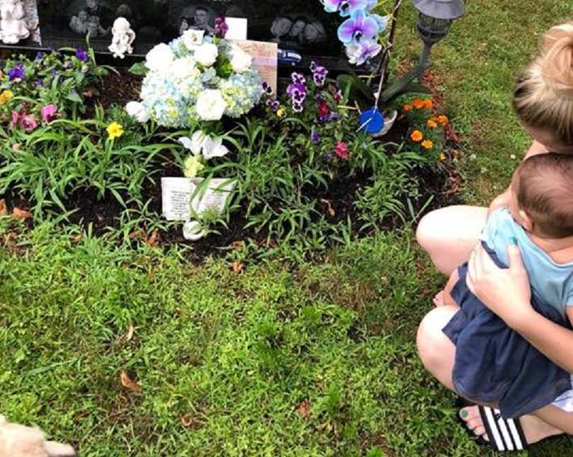 Sister cries while sitting next to her brother's gravestone