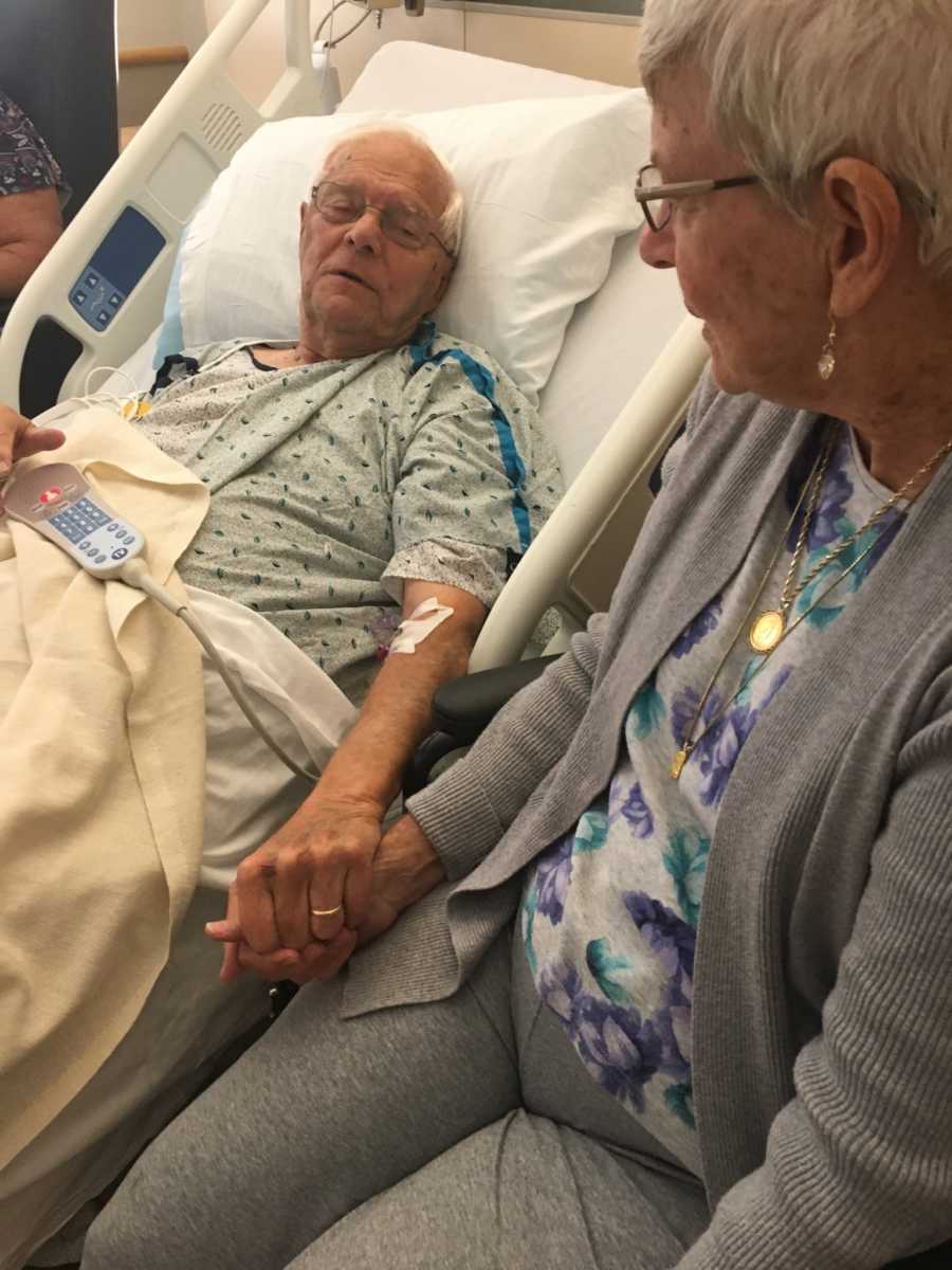 Husband and wife hold hands while husband lays in hospital bed after emergency