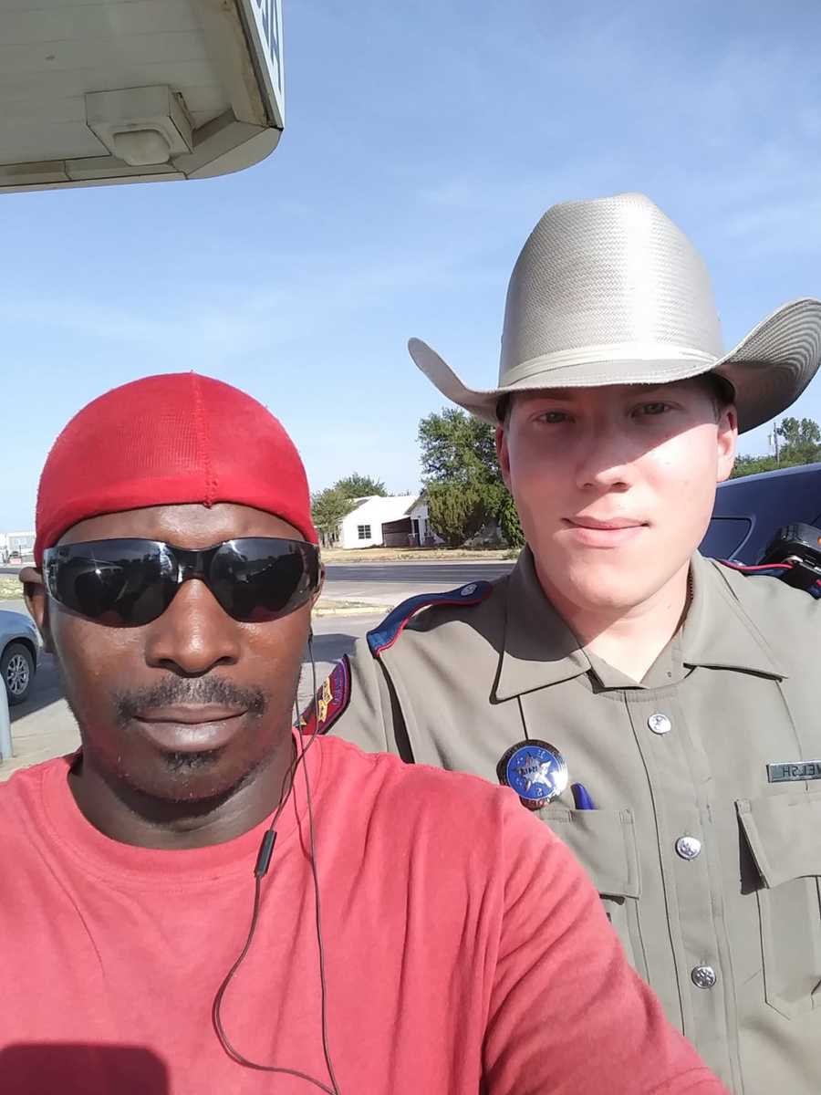 Black man takes a selfie with a young, white police officer