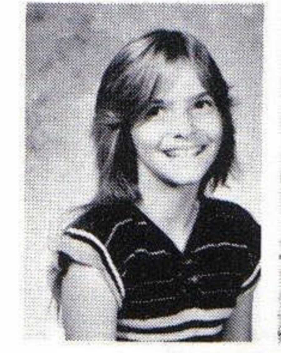 Young girl smiles for a school photo in striped t-shirt