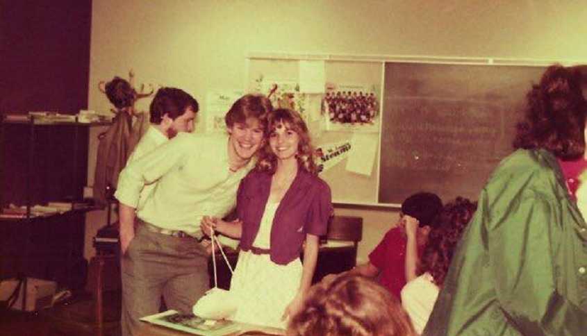 High school sweethearts smile for a photo while in the classroom together