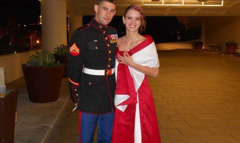 Couple pose for a photo in fancy outfits for a military ball