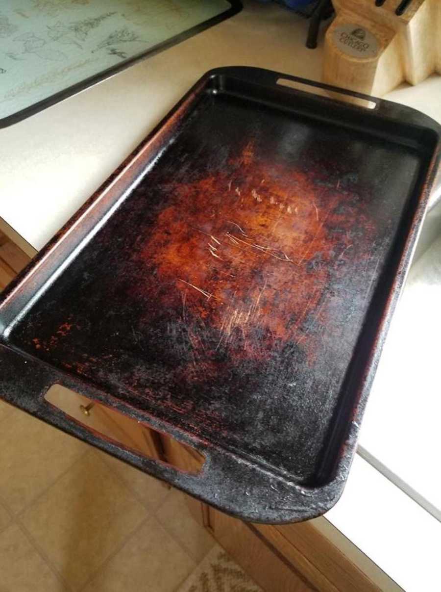 Woman snaps photo of old, worn out baking sheet
