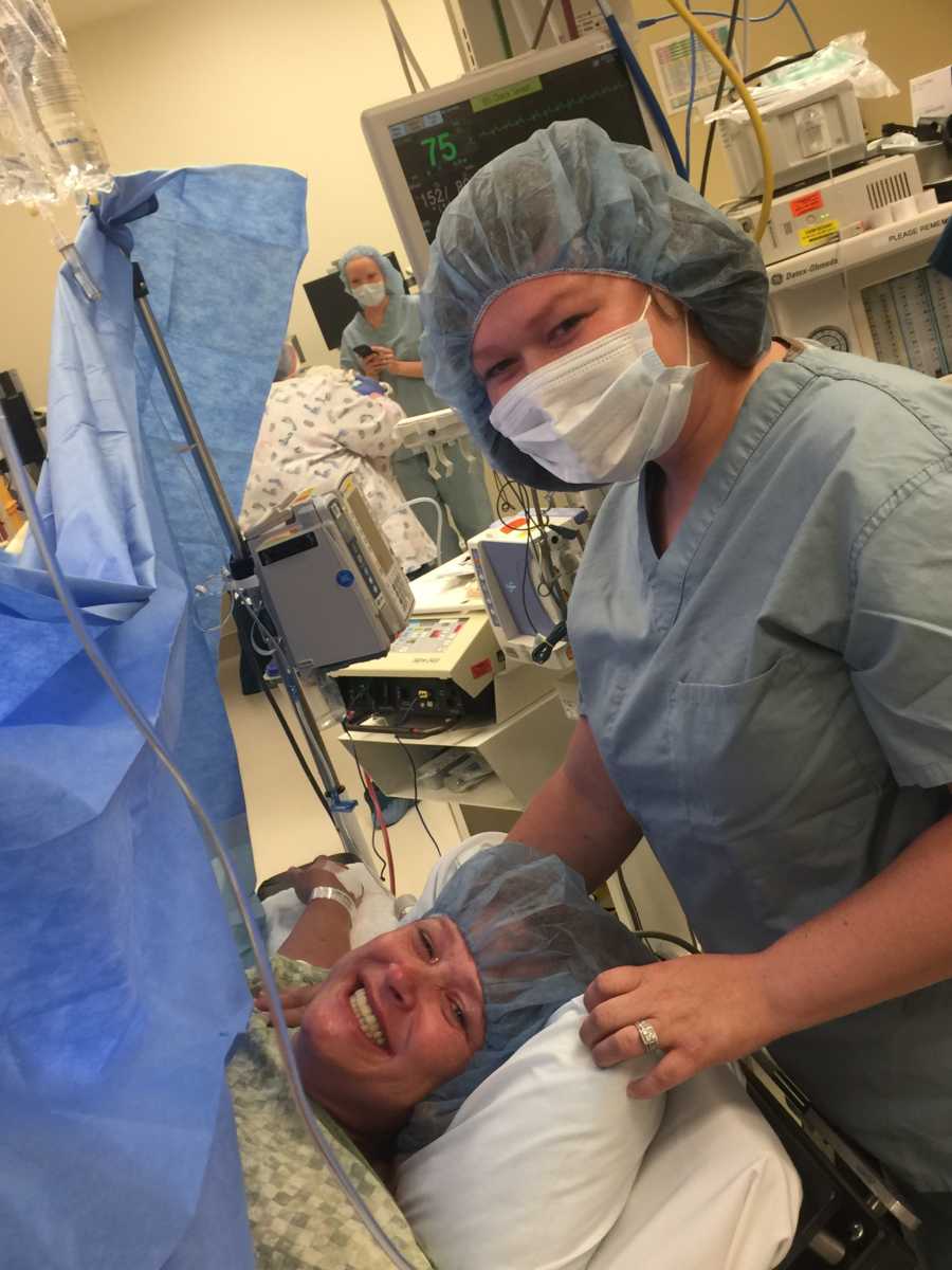 Daughter comforts her mother while she gives birth to her child