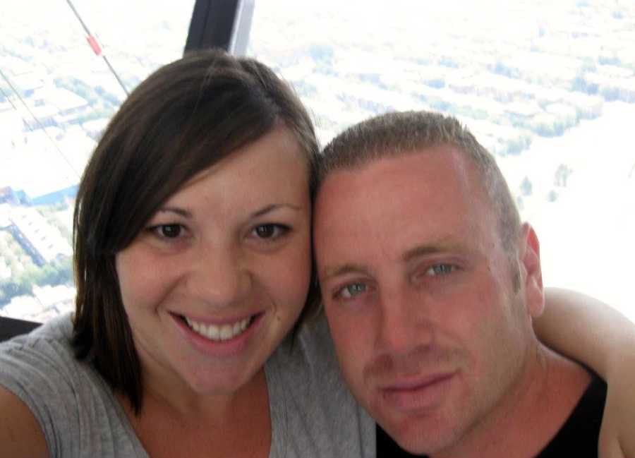 Married couple take a selfie from the top of a building with scenery behind them