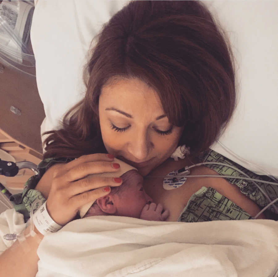 Woman holds her newborn baby to her chest after just giving birth to them