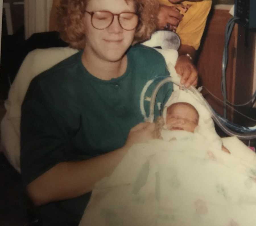 Mom holds newborn daughter connected to tubes in the hospital