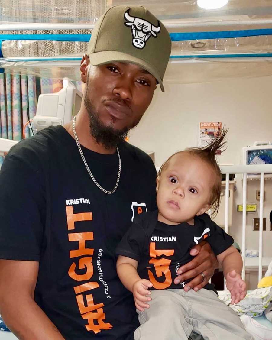 Proud dad holds his toddler son in the hospital