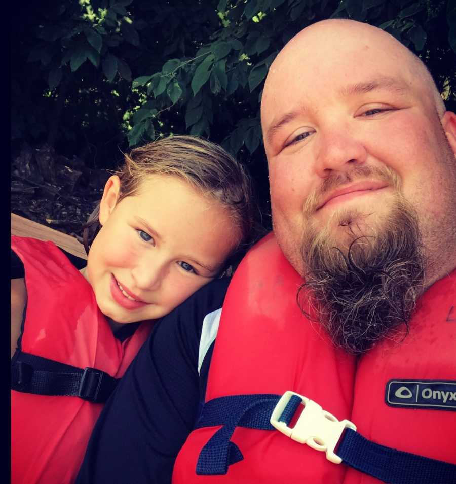 Father and daughter take a selfie while wearing life jackets