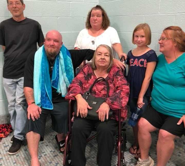 Man recovering from drug addiction takes a group photo with his family