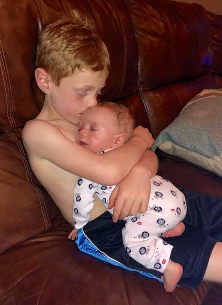 Brothers cuddle and sleep together on the couch