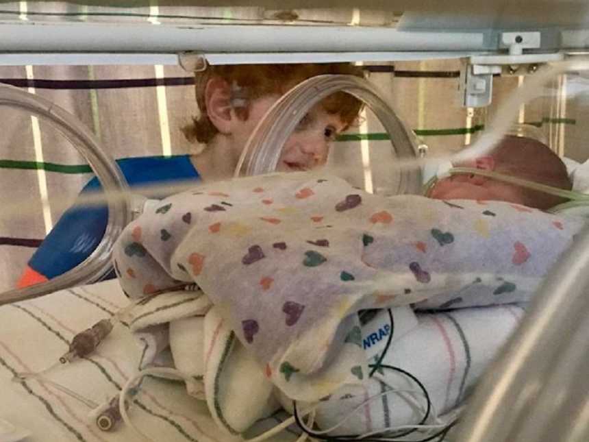 Big brother marvels at his newborn sibling in the NICU