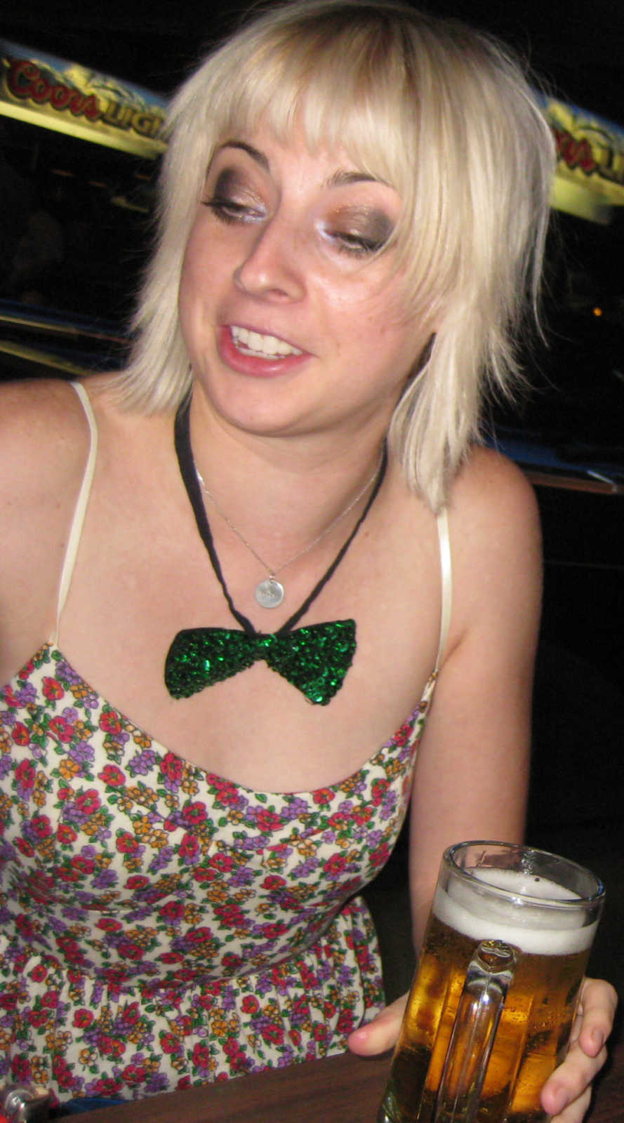 Woman with blonde pixie cut takes a candid photo while out partying