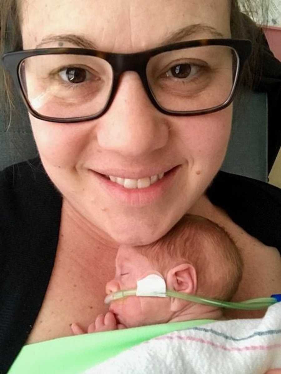 Woman takes a selfie holding her newborn special needs son
