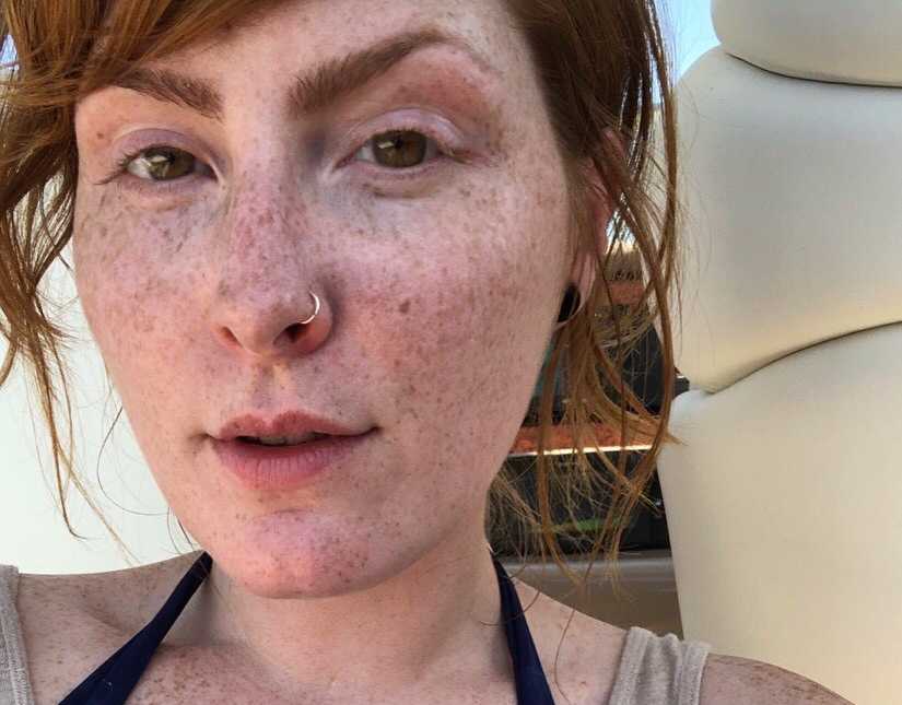 Woman recovering from addiction takes a car selfie after a day at the beach, showing off her freckles