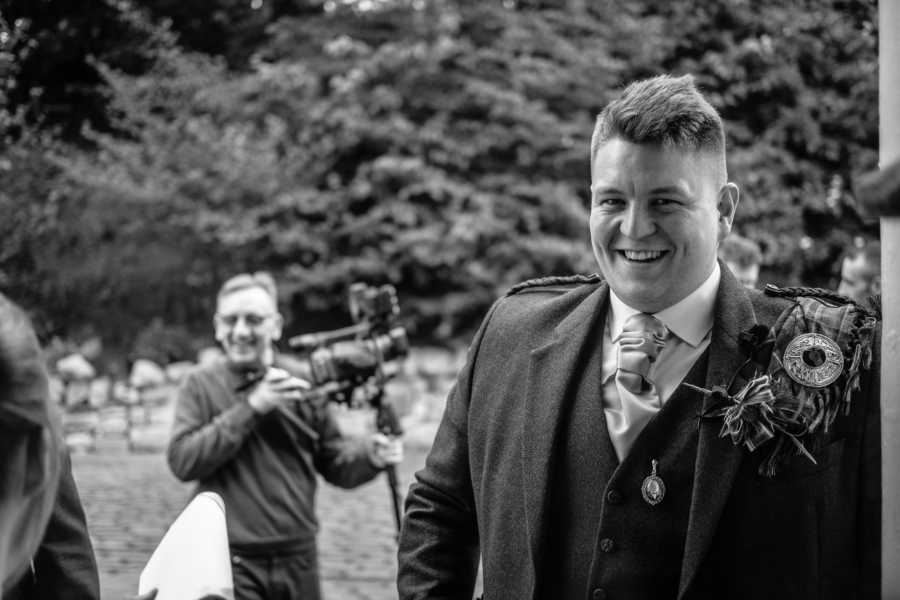 Man smiles for candid photo on his wedding day