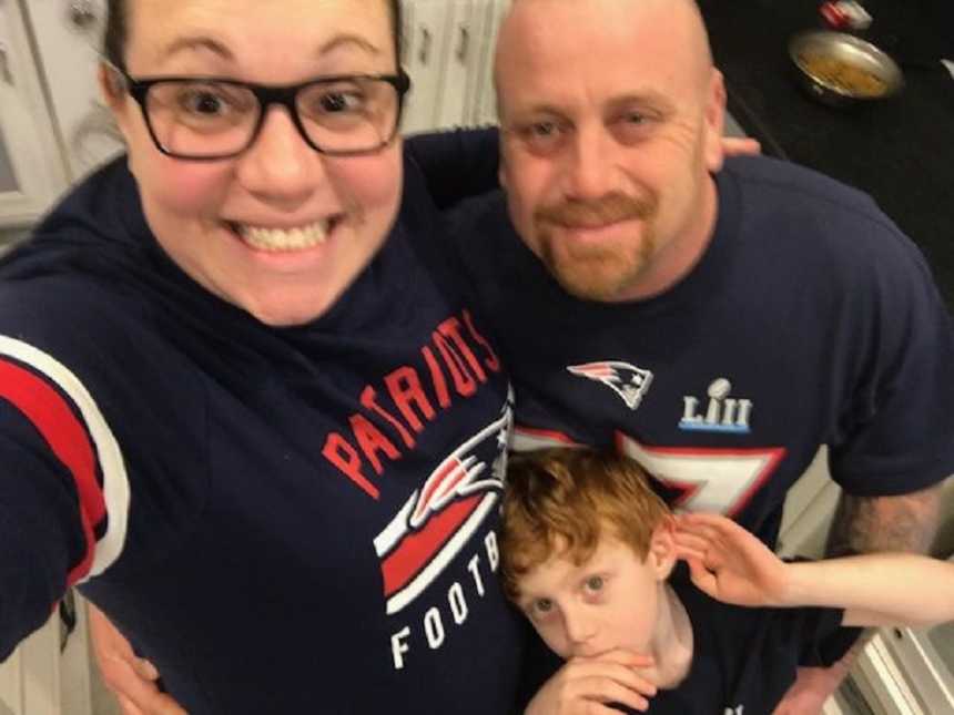 Married couple take a selfie with their son in matching Patriots shirts
