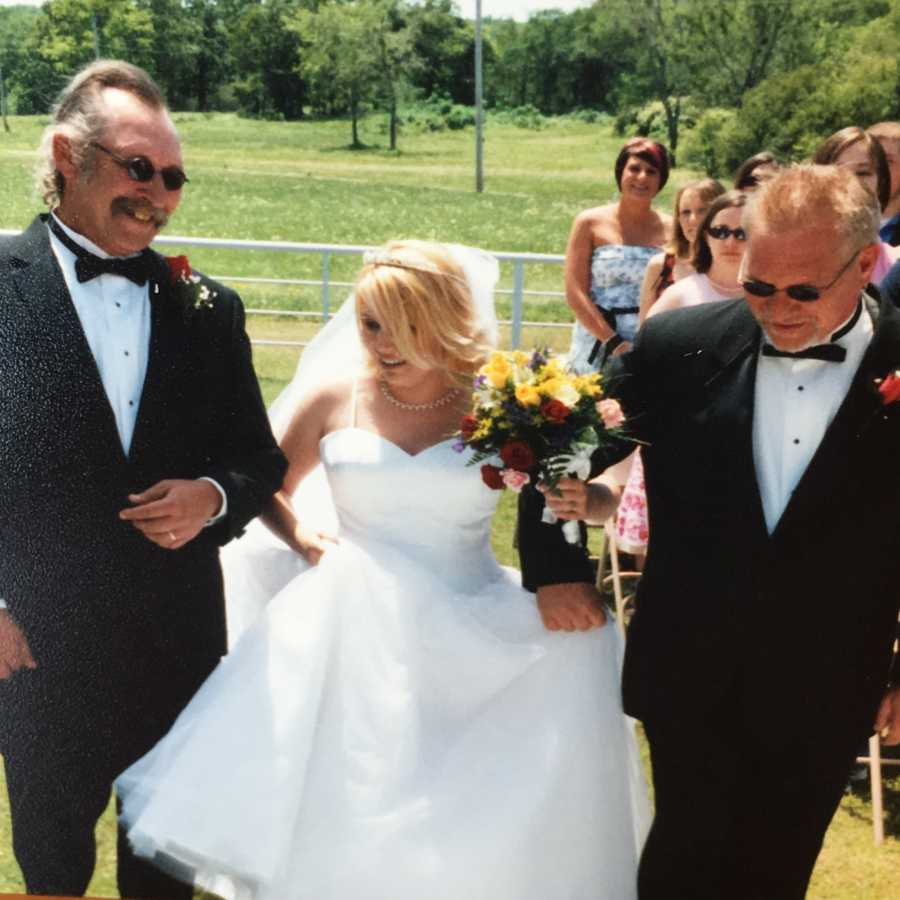 Dad and stepdad walk their shared daughter down the aisle on her wedding day