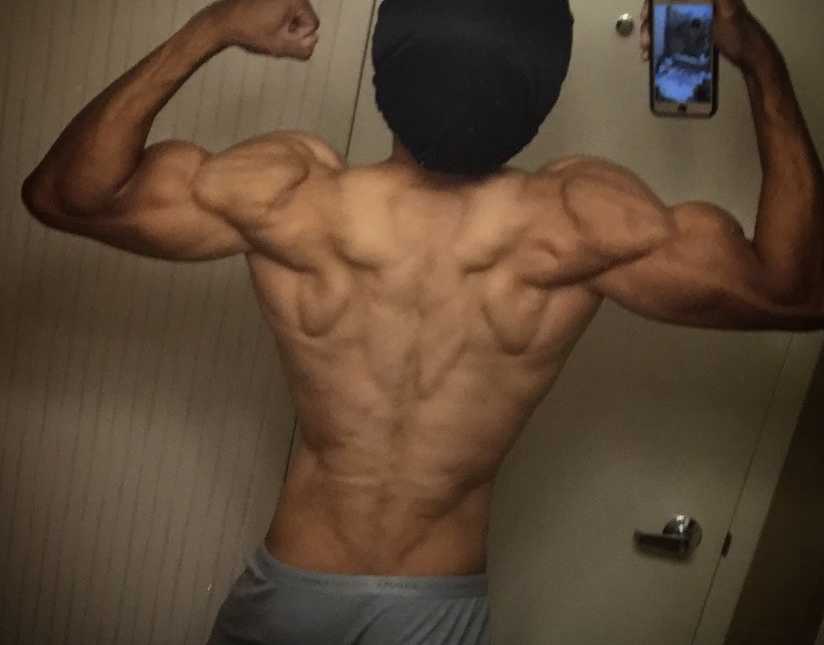 Man takes a mirror selfie while flexing his back