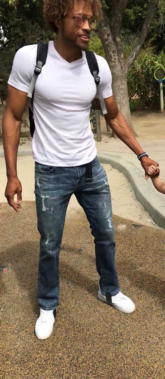 Man looks caught off-guard for a photo while holding a child's hand
