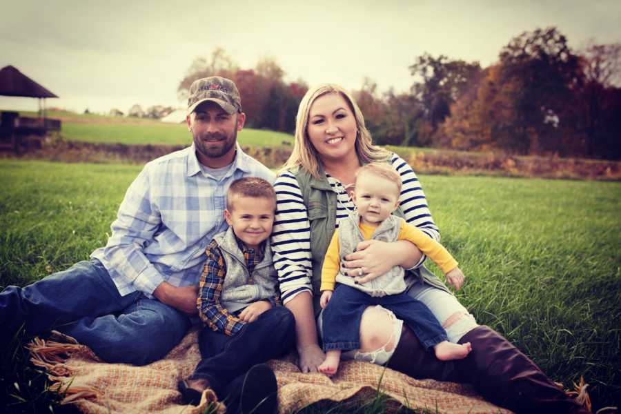 Family of four take fall-themed photos together on a farm