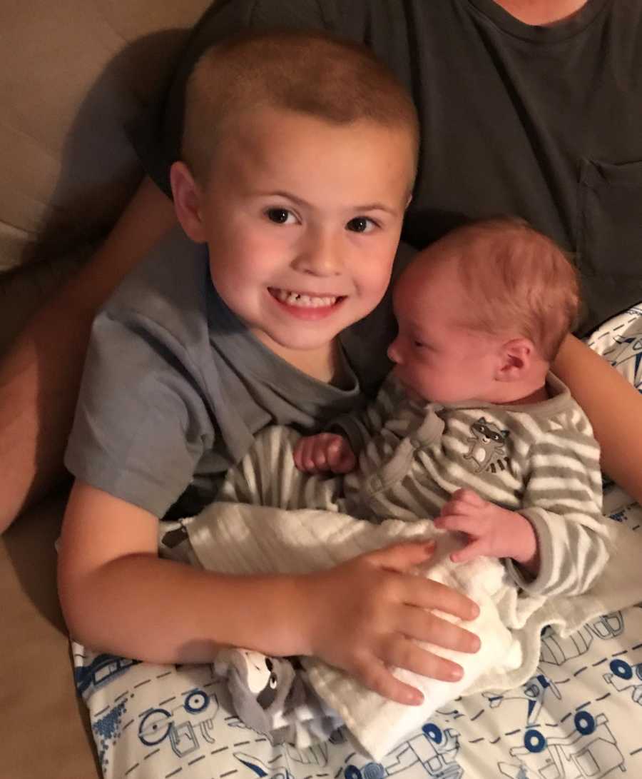 Big brother holds his newborn brother after he comes home from the hospital