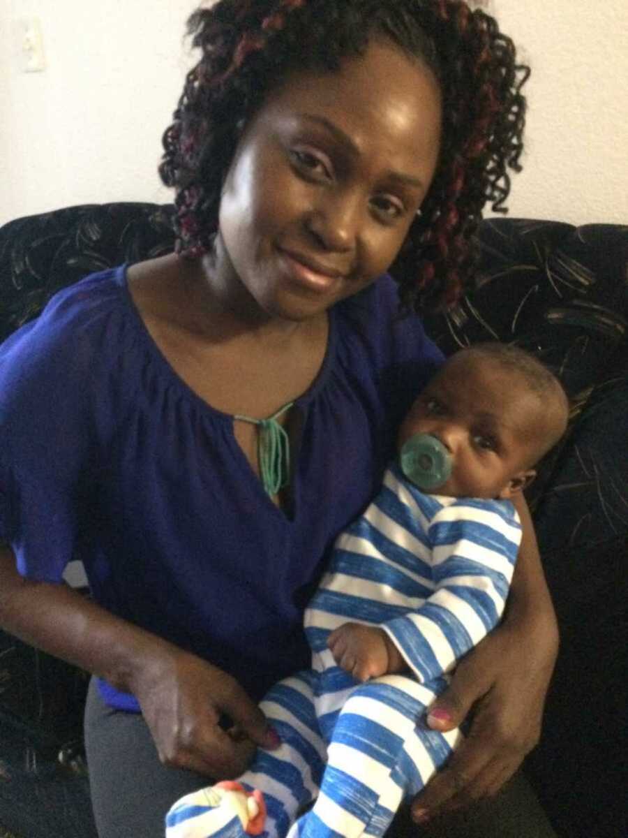 Biological mother holding newborn baby in striped pajamas