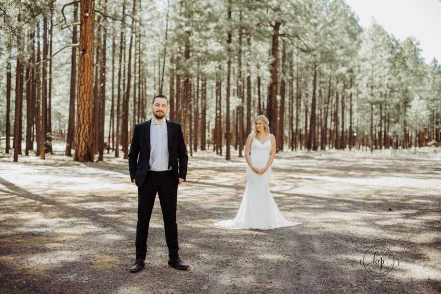 Bride standing behind groom in white dress