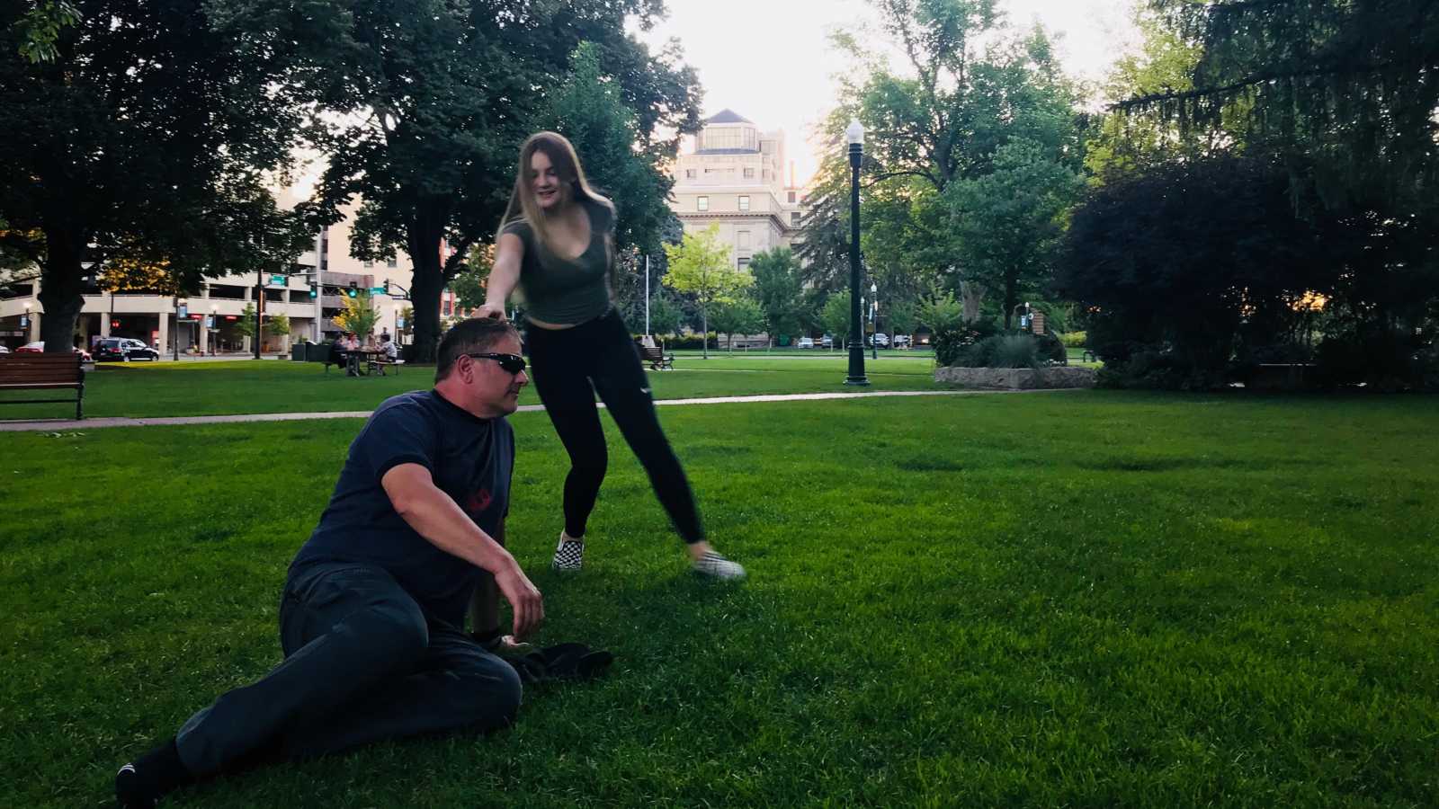 Father and daughter goof off while enjoying family time at a park together