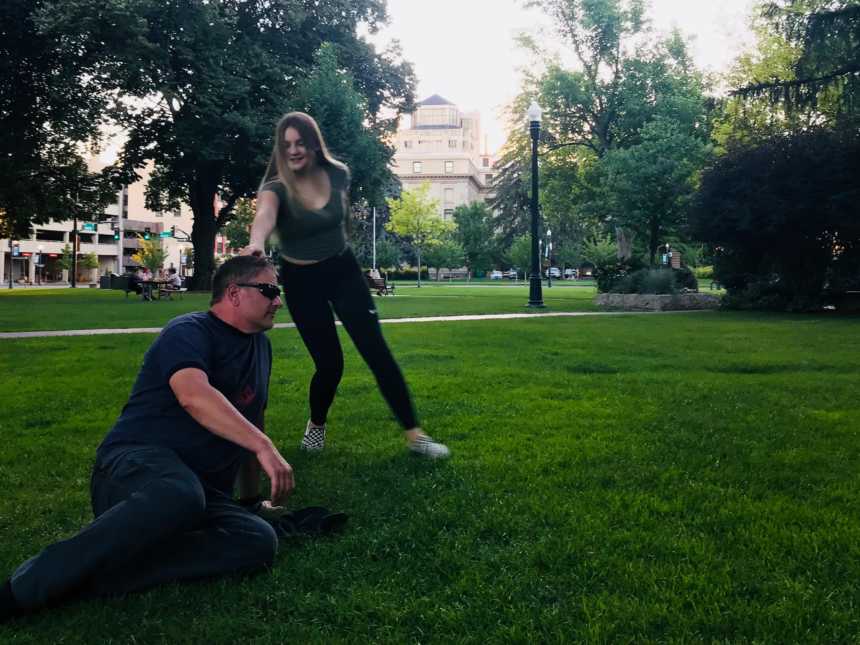 Father and daughter goof off while enjoying family time at a park together