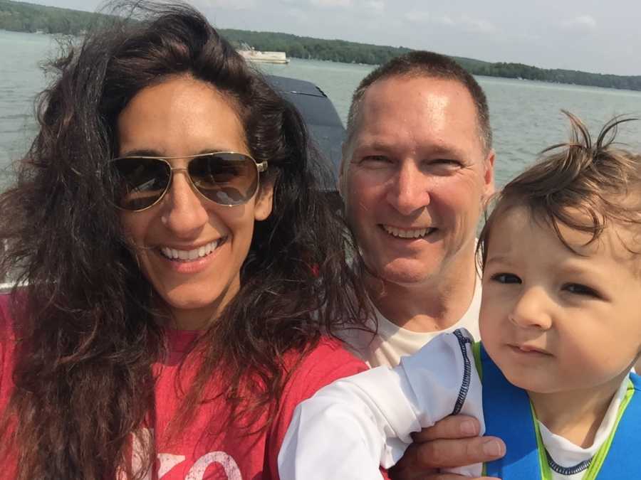 Grandparents take a selfie with their grandson while out on a boat