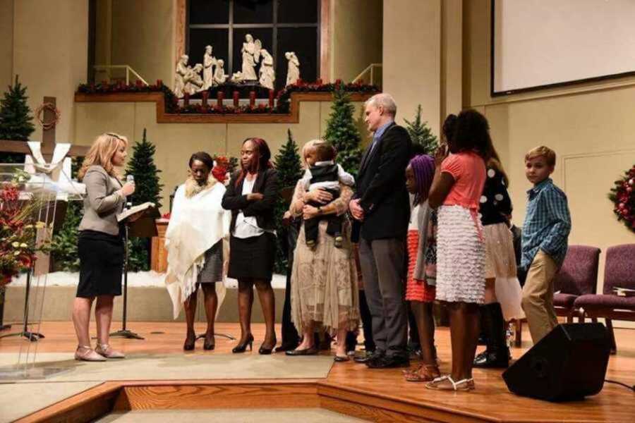 Family baptizing boy in church