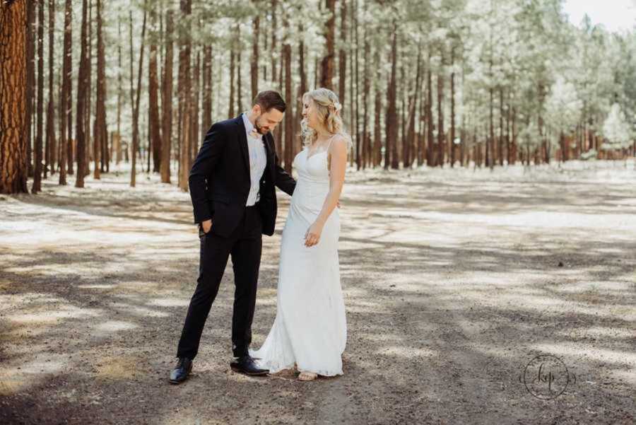 Groom looking at bride's wedding dress