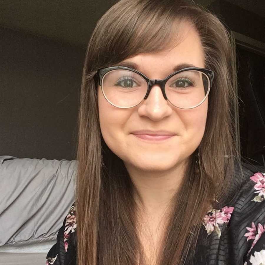 Young woman healing from childhood trauma takes a selfie in black-rimmed glasses