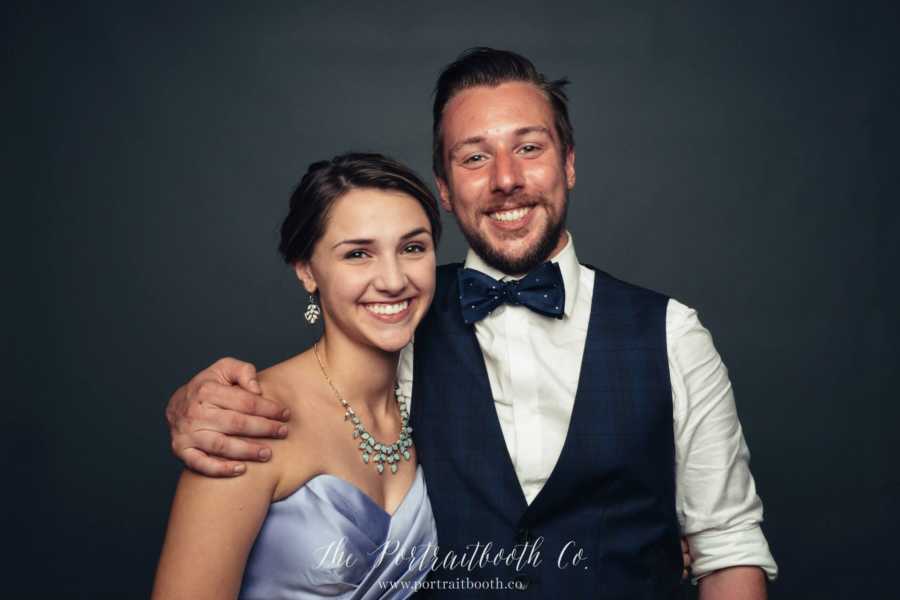 Bride's sister smiles for a photo with new brother-in-law during wedding reception