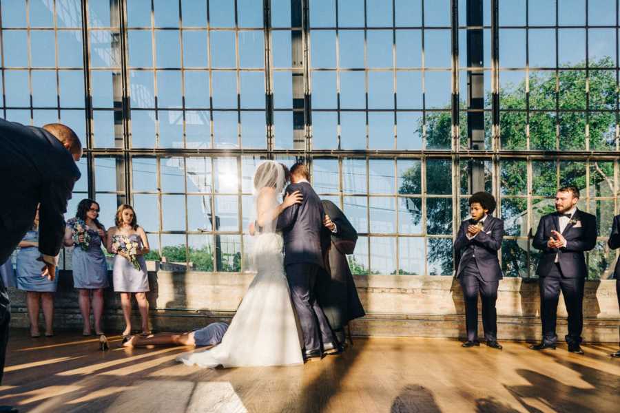 Everyone looks on as maid of honor falls to the ground and faints due to heat in greenhouse