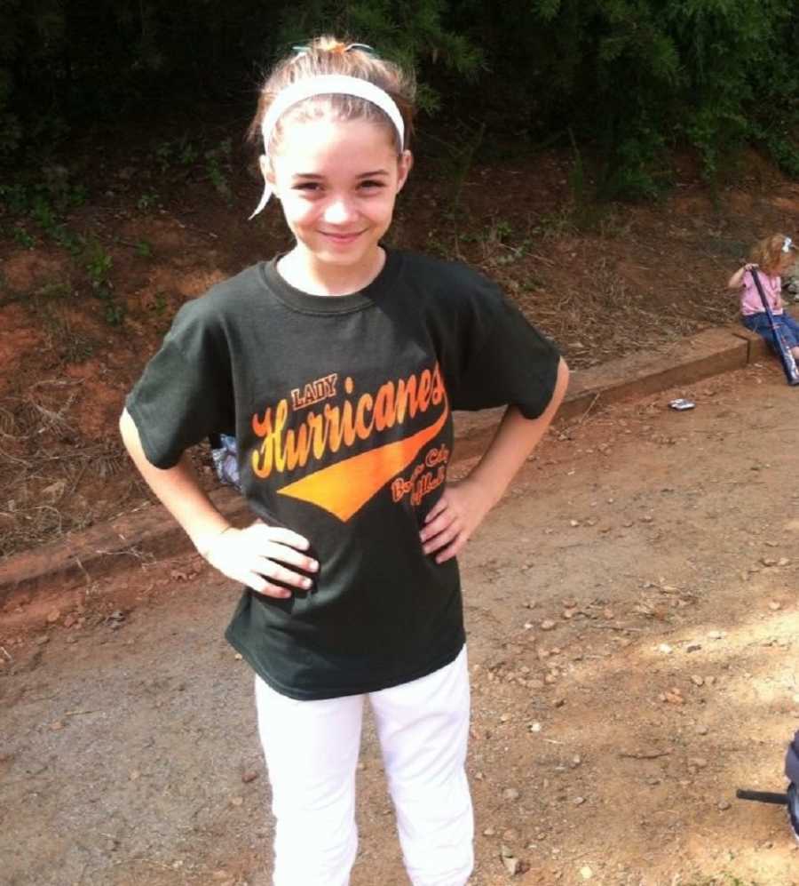 Mom snaps a photo of her daughter in her softball uniform before a game