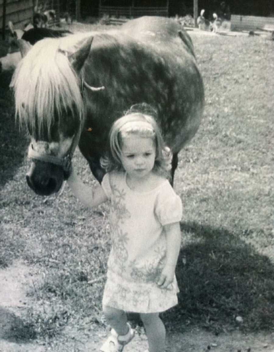 Little girl holds the lead on a pony 