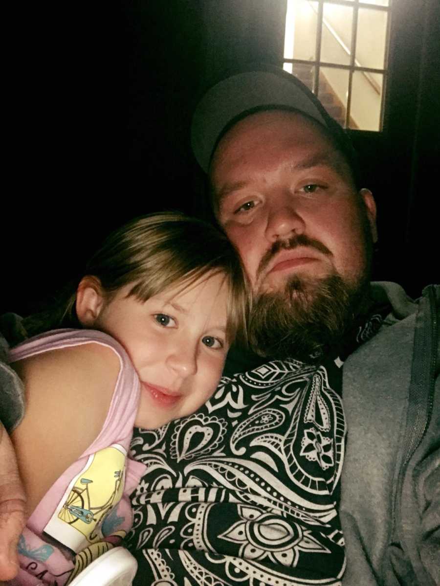 Dad recovering from drug addiction cuddles with his young daughter