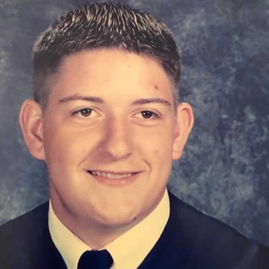 Teen boy smiles for his high school senior portrait