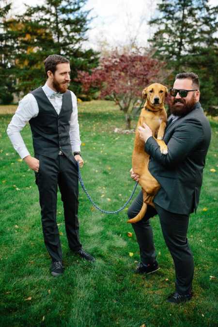 Man who became sober and lost weight holds his dog next to his brother 