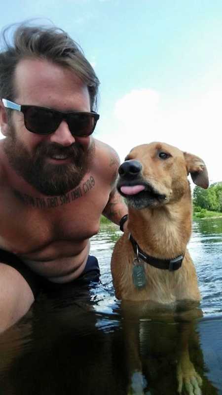 Recovered alcoholic who lost weight smiles in selfie in water with dog