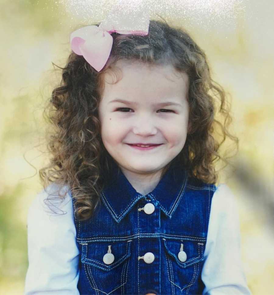 Little girl whose mother is nervous for her to start school smiles with big pink in hair 