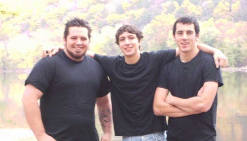 Man who was an alcoholic standing next to two brothers who are all wearing black t-shirts
