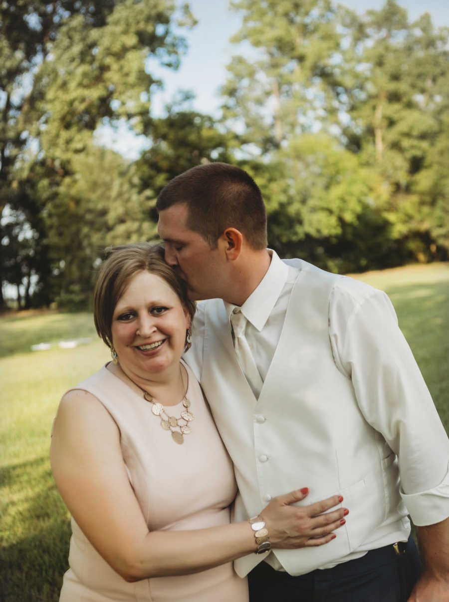 Groom kisses mother with breast cancer on head