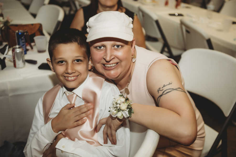 Woman with breast cancer hugs youngest son at oldest son's wedding