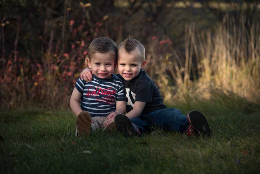 Toddlers smiling in grass who give their mother a hard time