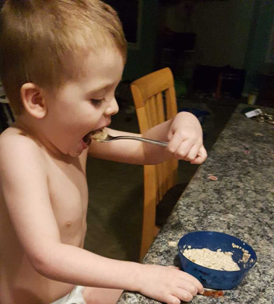 Toddler eats oatmeal at counter